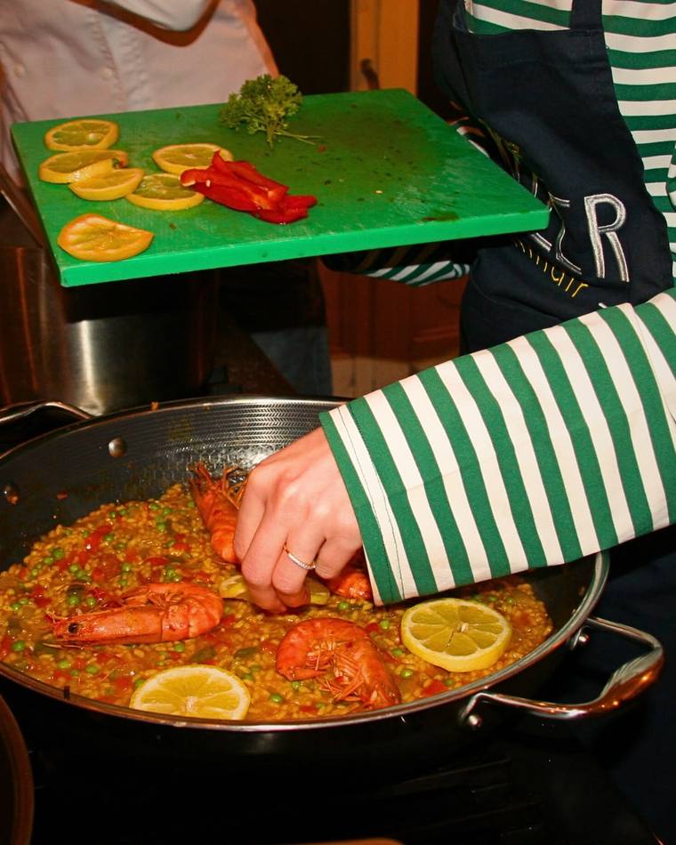 Fresh prawns being arranged onto a paella pan
