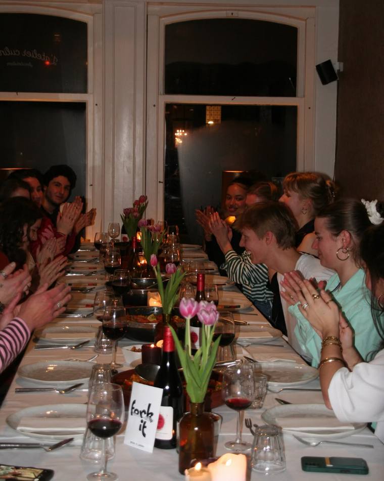Guests applauding around the table after a Fork It paella workshop