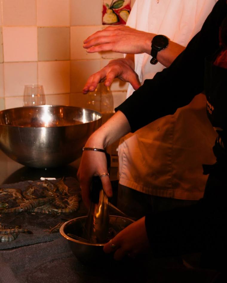 Hands preparing fresh prawns for a Fork It paella