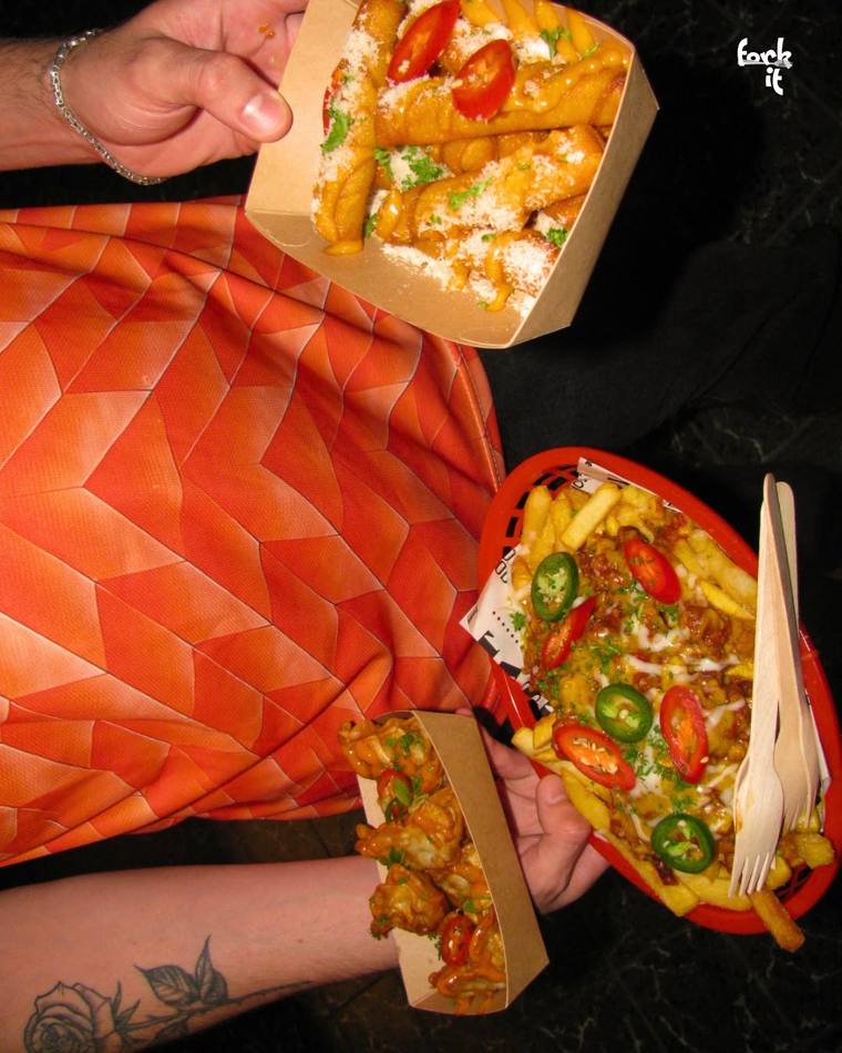Loaded fries and bites held up during a football match day
